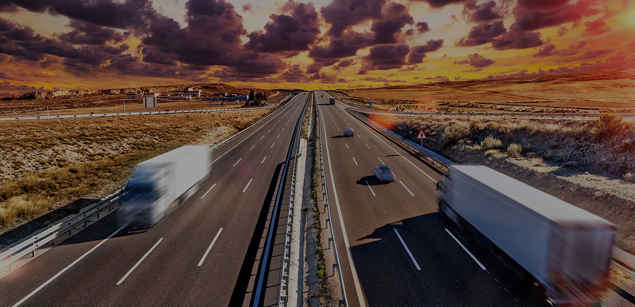Trucks on highway during sunset