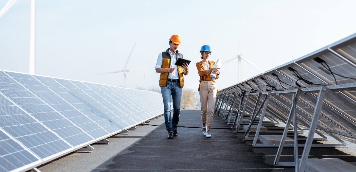 Two people in front of solar panels