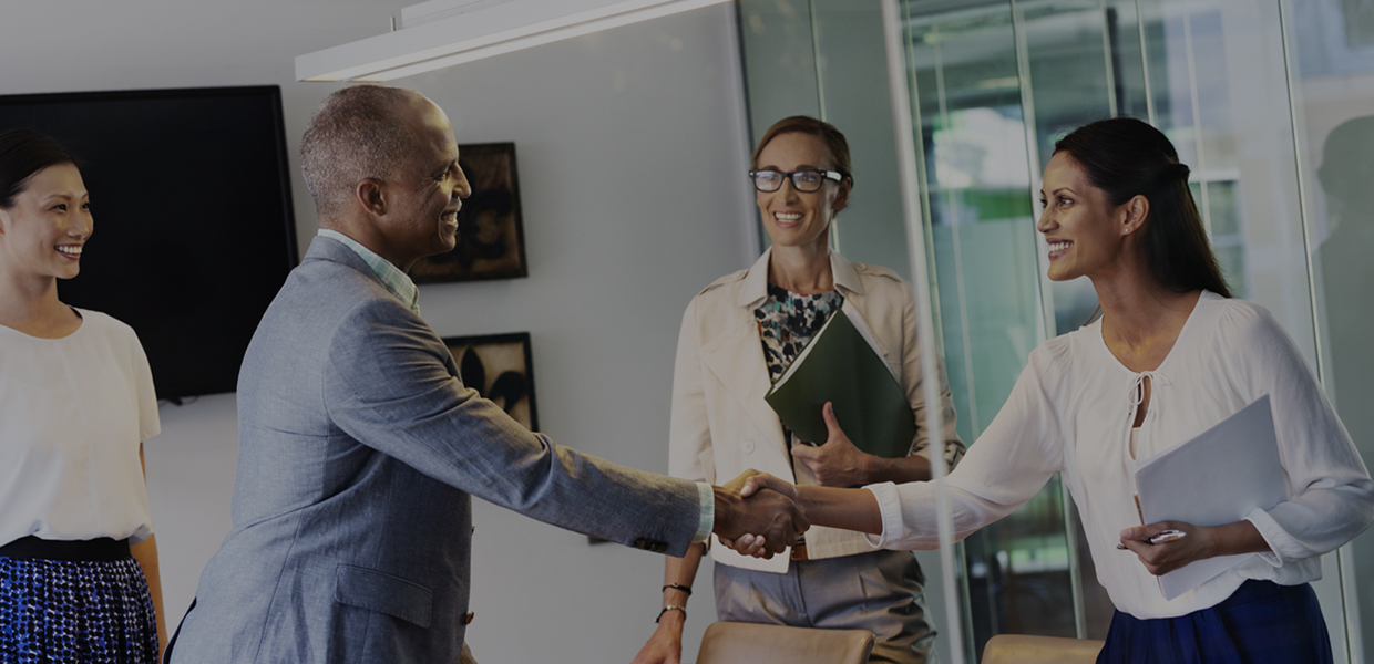 Employees shaking hands in office setting